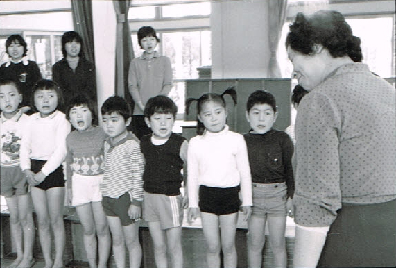 歌う子どもたちと、笑いかける斎藤公子