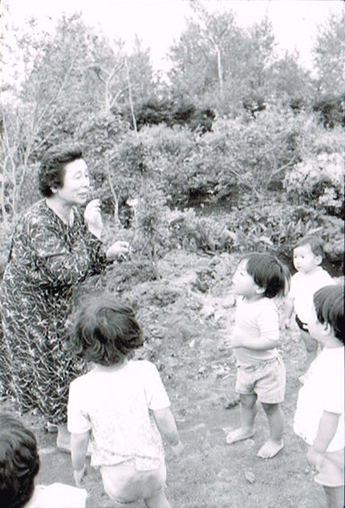 屋外で、斎藤先生と子どもたち6